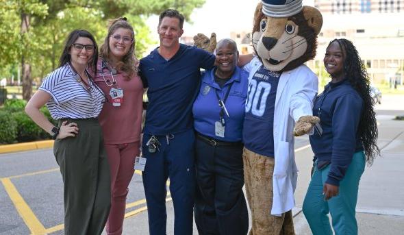 A group of people pose for a photo with Old Dominion University's mascot.