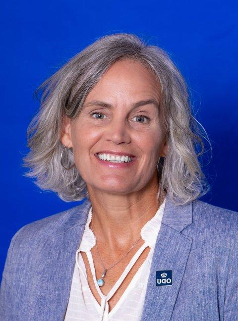 Woman smiling in front of blue background